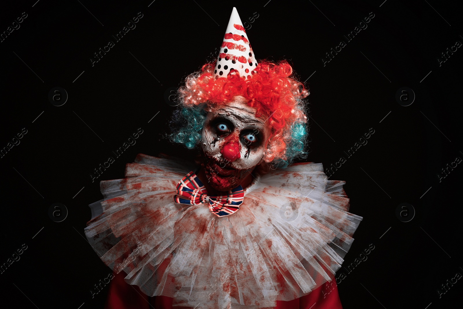 Photo of Terrifying clown on black background. Halloween party costume