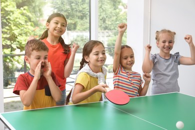 Photo of Cute happy children playing ping pong indoors