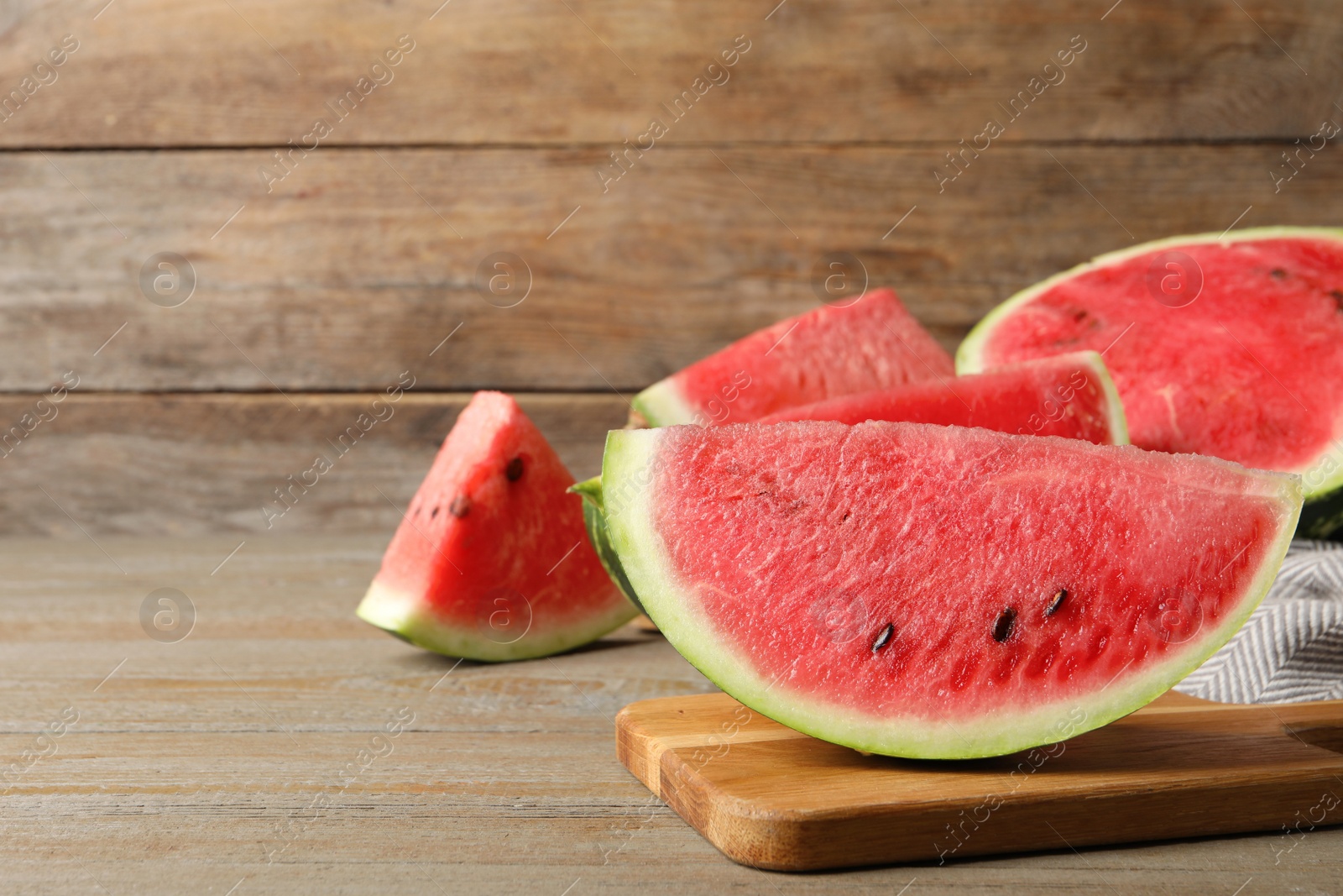 Photo of Delicious fresh watermelon slices on wooden table. Space for text