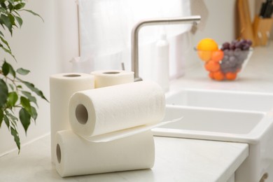 Rolls of paper towels on white countertop in kitchen. Space for text