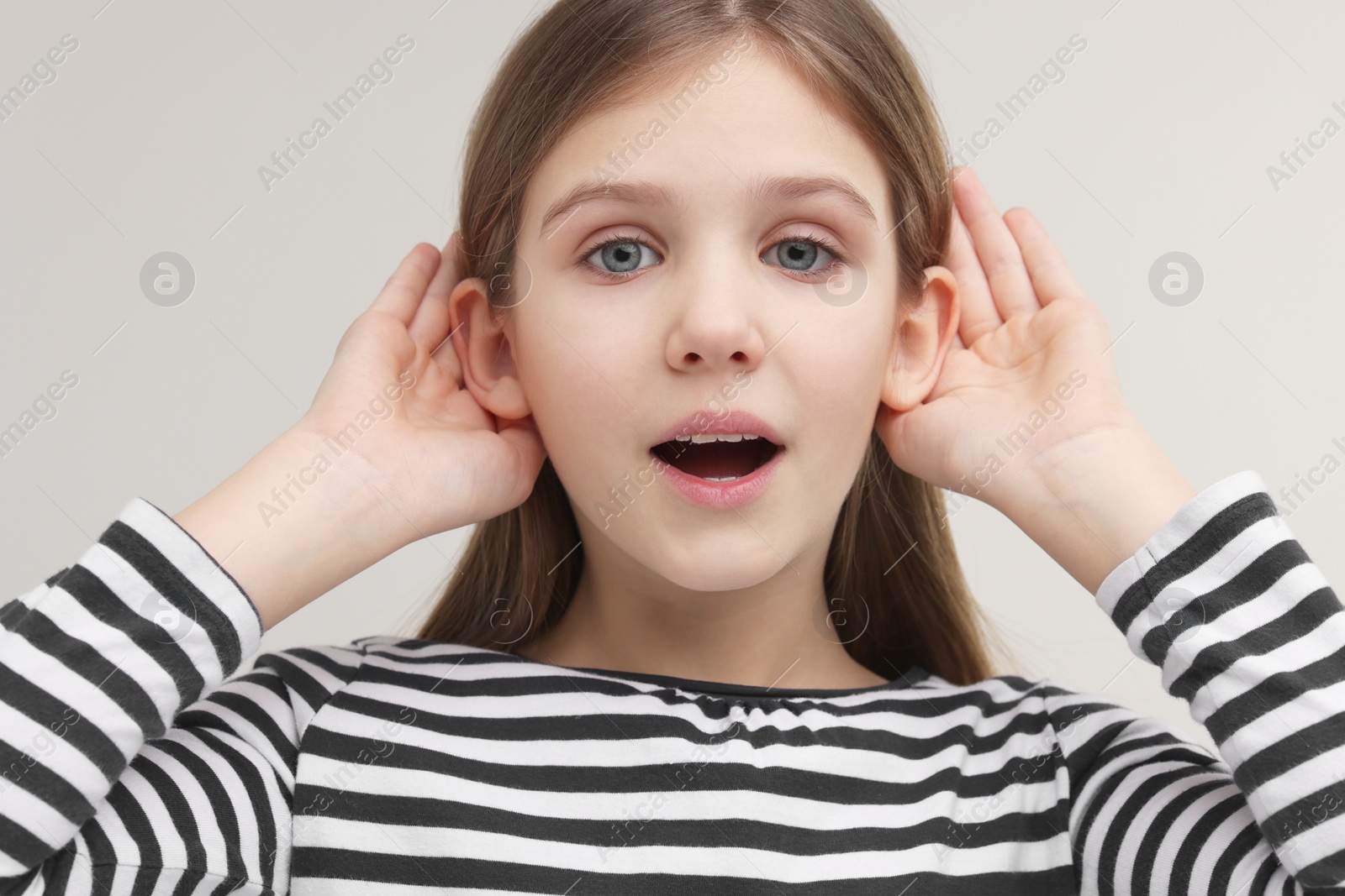 Photo of Little girl with hearing problem on grey background