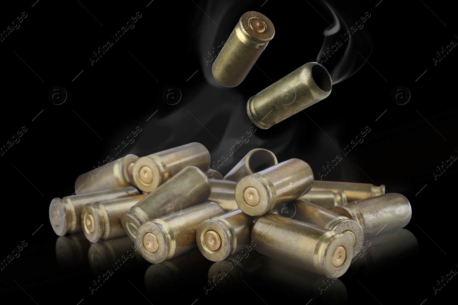 Image of Cartridge cases with smoke falling onto other against black background