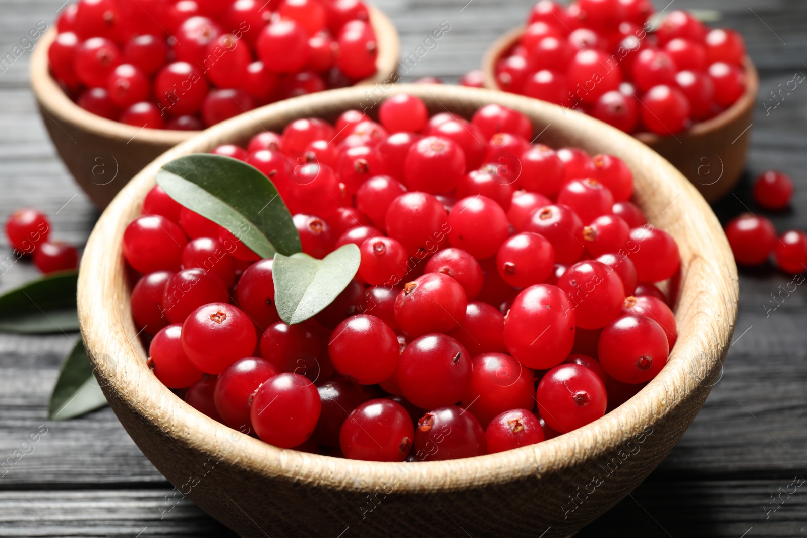 Photo of Ripe fresh cranberry on grey wooden table, closeup