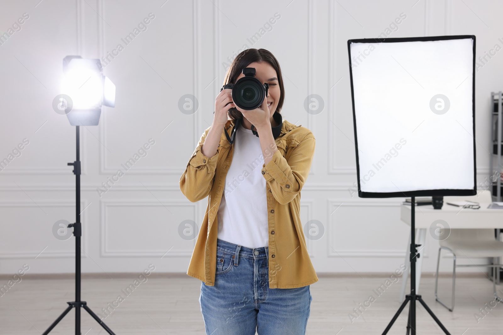 Photo of Professional photographer taking picture in modern photo studio