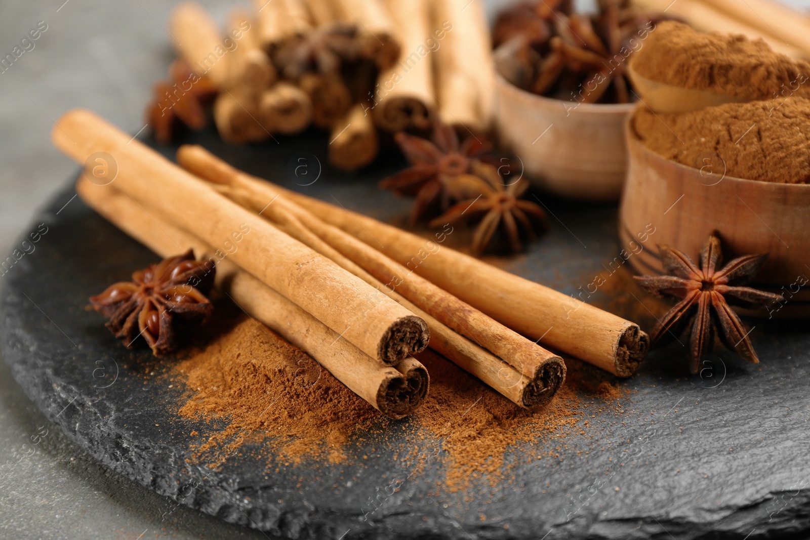 Photo of Aromatic cinnamon and anise on slate plate, closeup