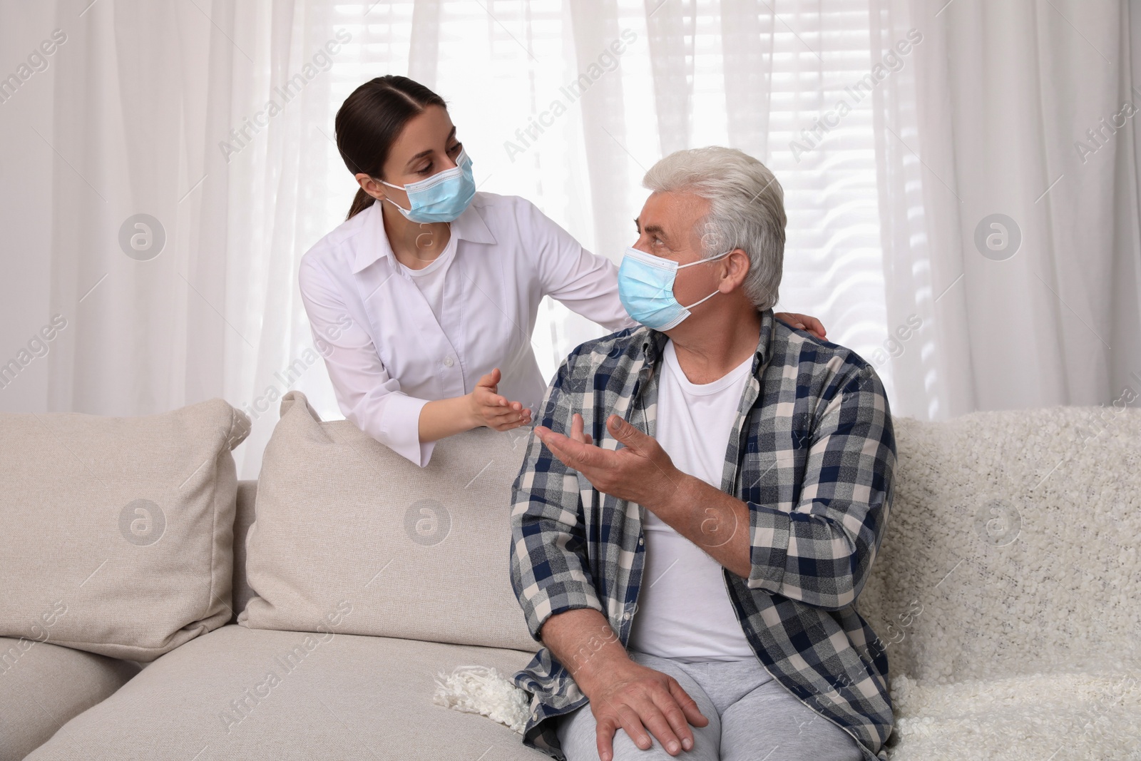 Photo of Doctor taking care of senior man with protective mask at nursing home