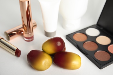 Image of Fresh ripe palm oil fruits and cosmetic products on white background, closeup