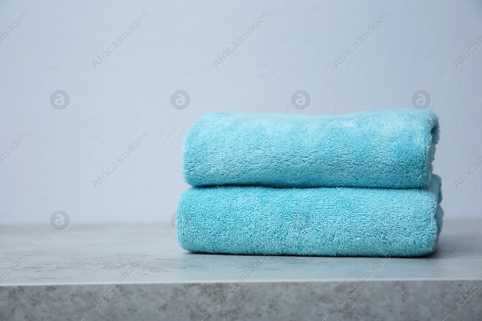Photo of Stack of towels on table against grey background