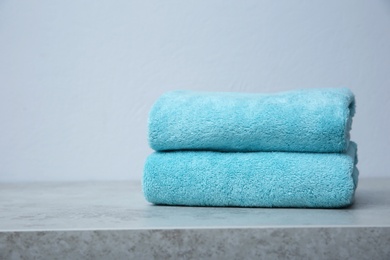 Stack of towels on table against grey background