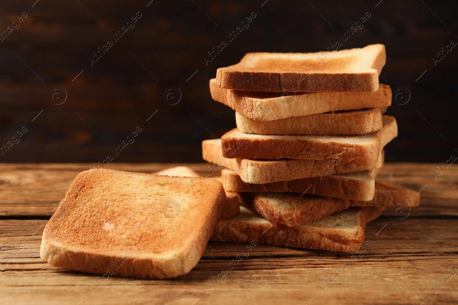 Photo of Slices of tasty toasted bread on wooden table