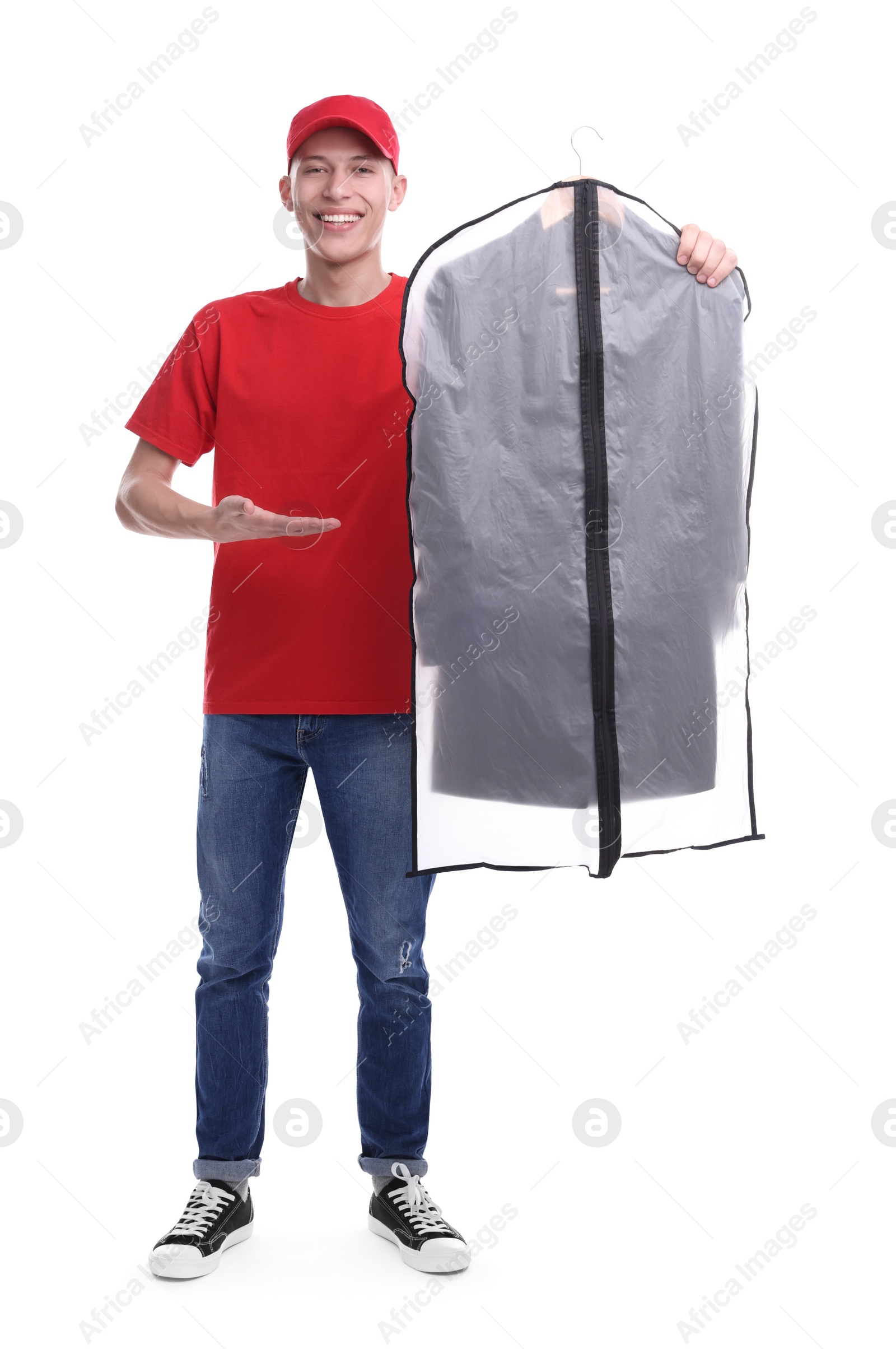 Photo of Dry-cleaning delivery. Happy courier holding garment cover with clothes on white background