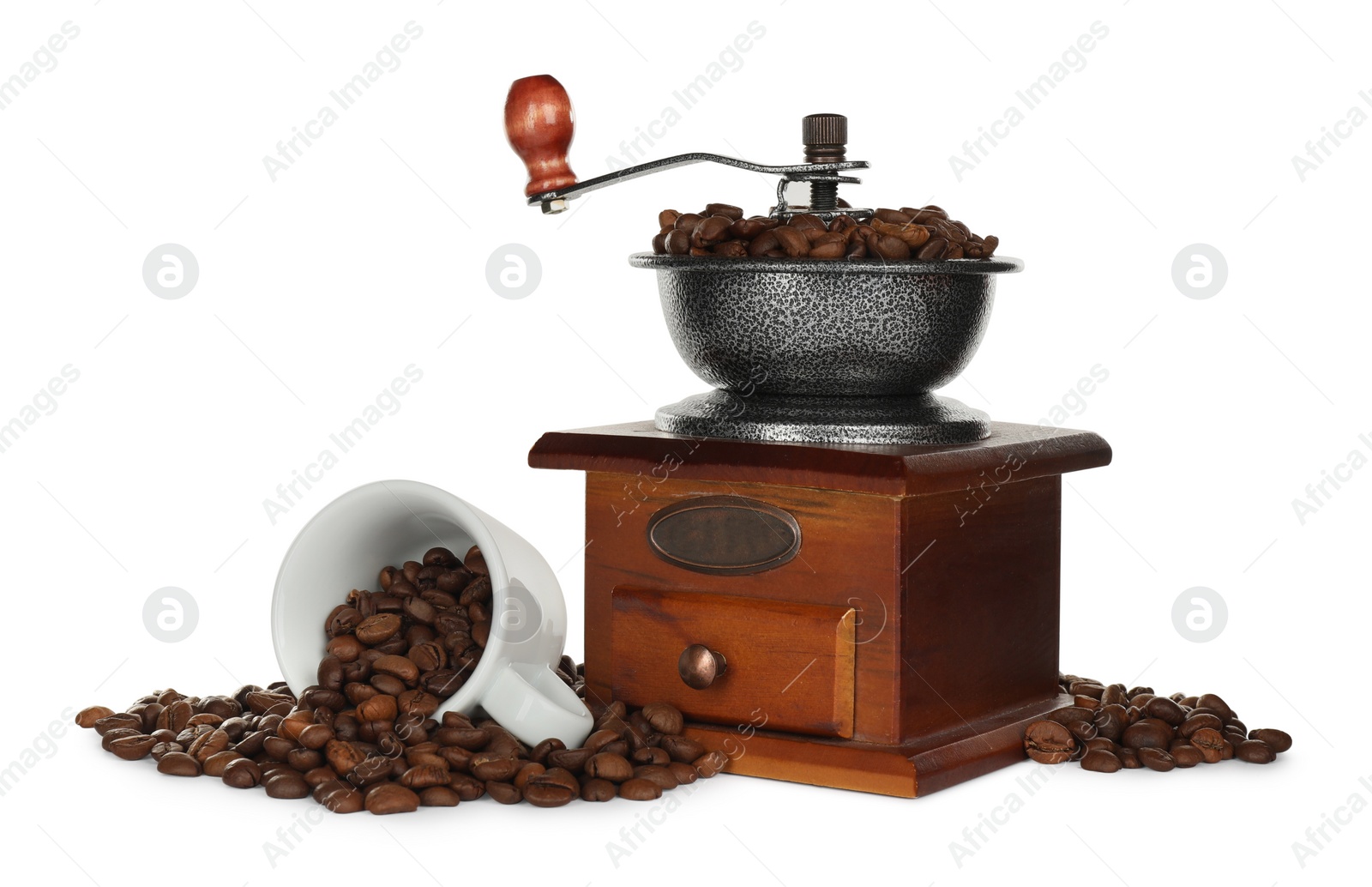 Photo of Vintage manual coffee grinder with beans and cup on white background