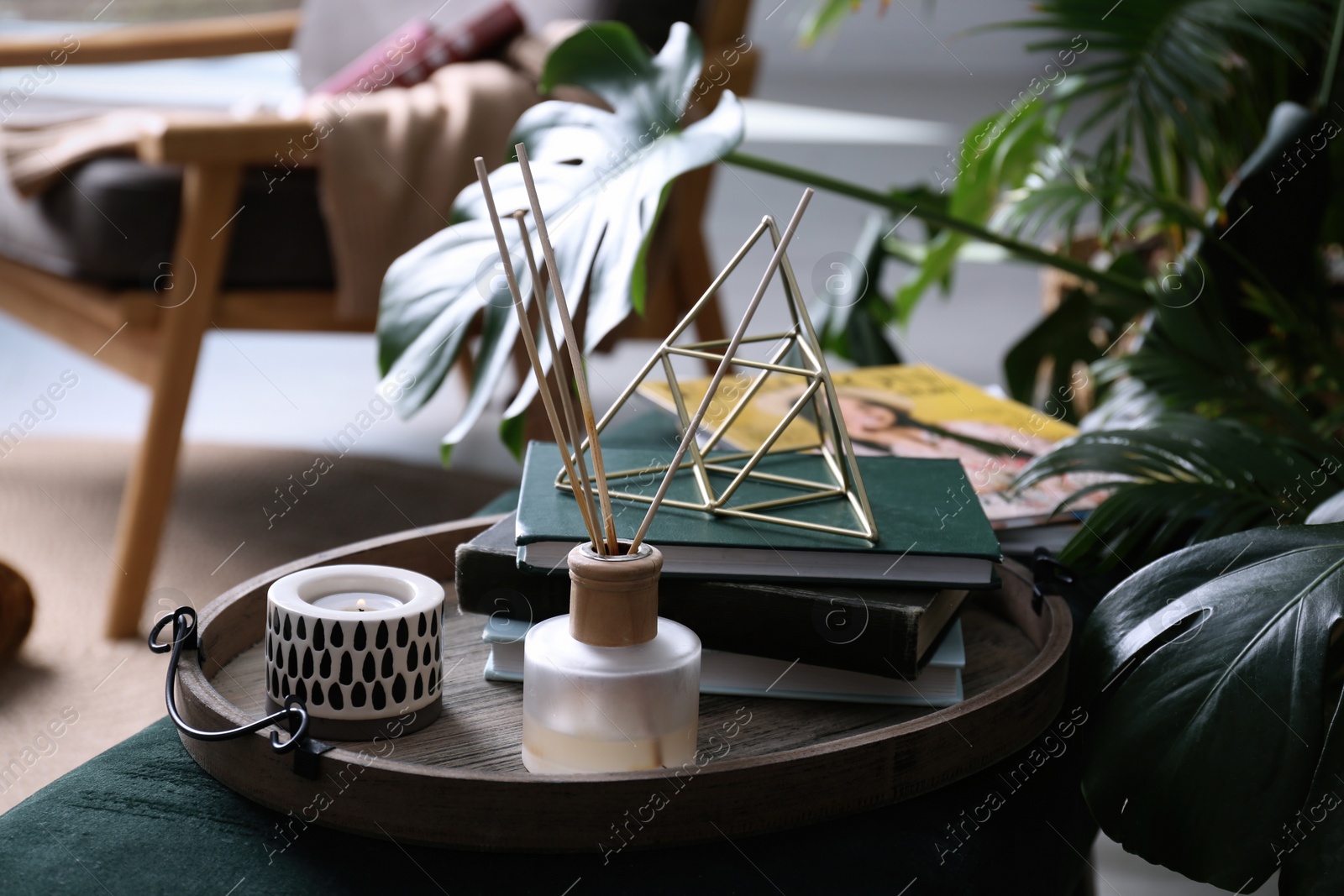 Photo of Wooden tray with decorations and books on bench indoors