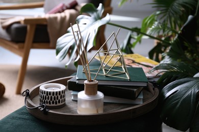 Photo of Wooden tray with decorations and books on bench indoors