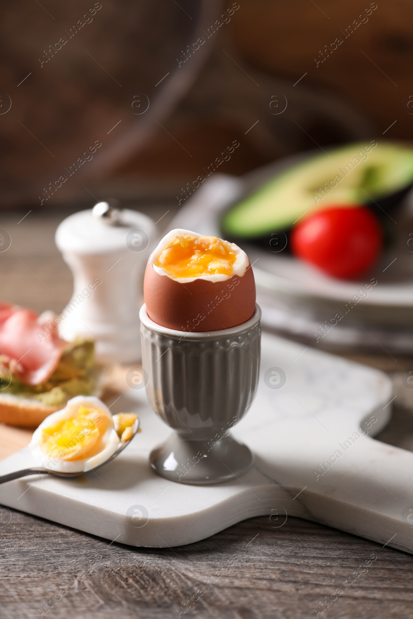 Photo of Soft boiled chicken egg served on wooden table