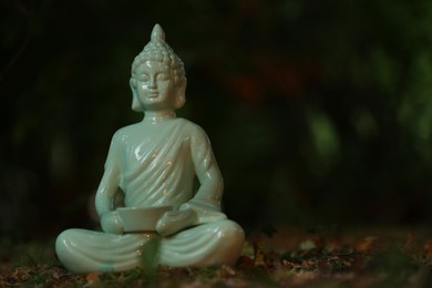 Photo of Decorative Buddha statue on ground outdoors, space for text