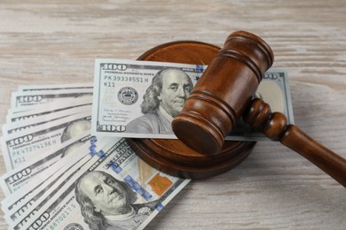 Photo of Judge's gavel and money on wooden table, closeup