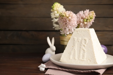 Photo of Traditional cottage cheese Easter paskha and decorative bunnies on wooden table, space for text