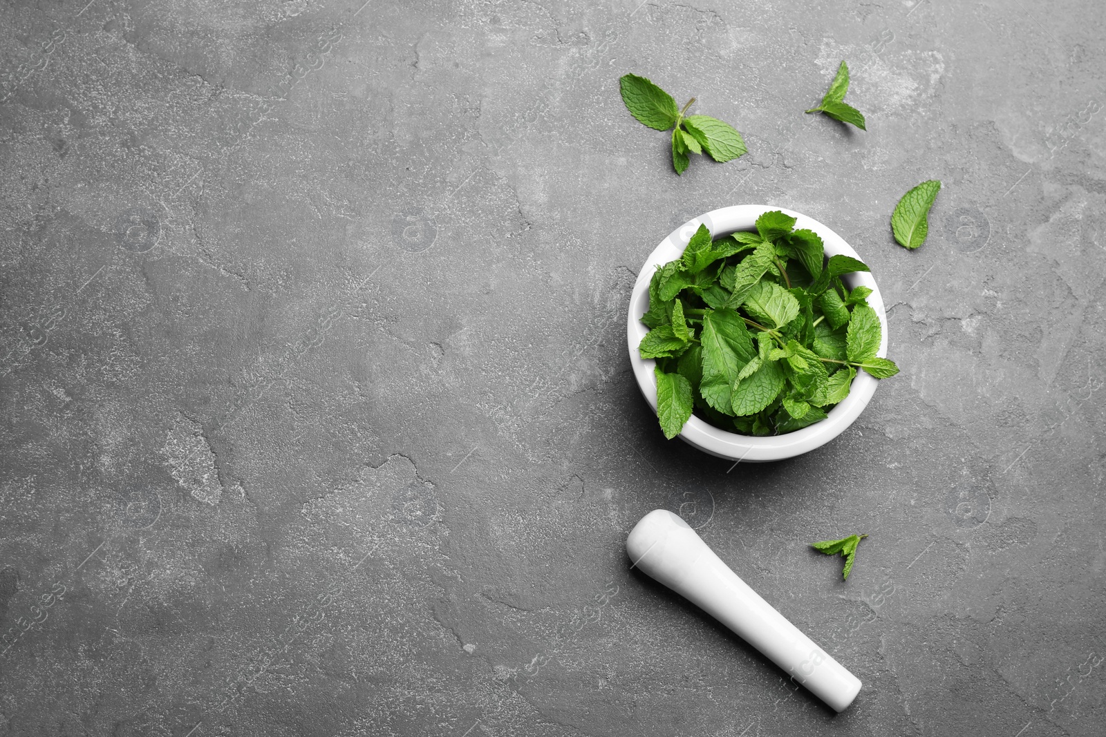 Photo of Fresh mint with mortar and pestle on grey background, flat lay. Space for text