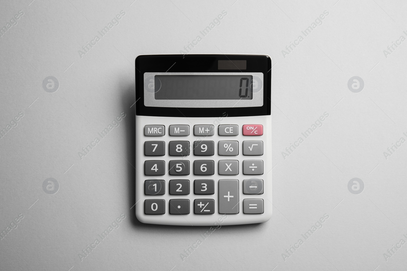 Photo of Calculator on light gray background, top view. Office equipment