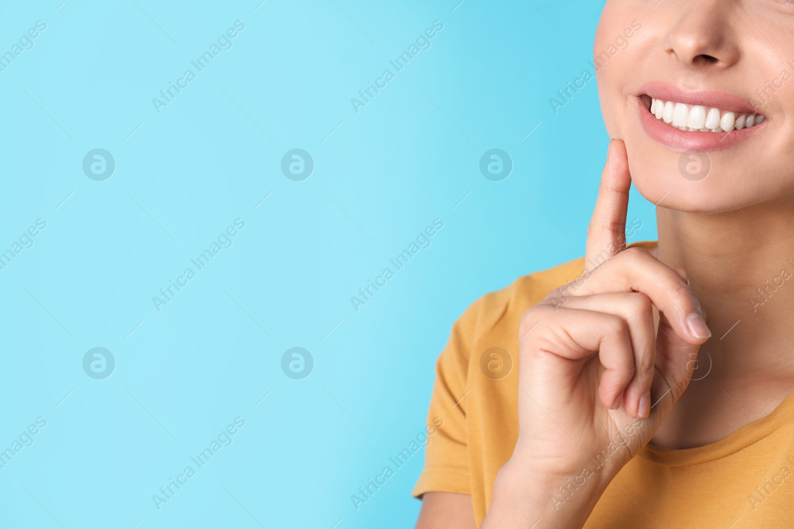 Photo of Young woman with healthy teeth on color background, closeup. Space for text