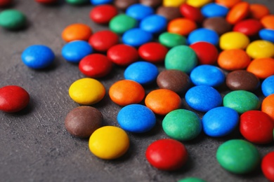 Colorful candies on grey background, closeup