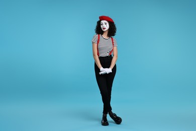 Photo of Funny mime with beret posing on light blue background