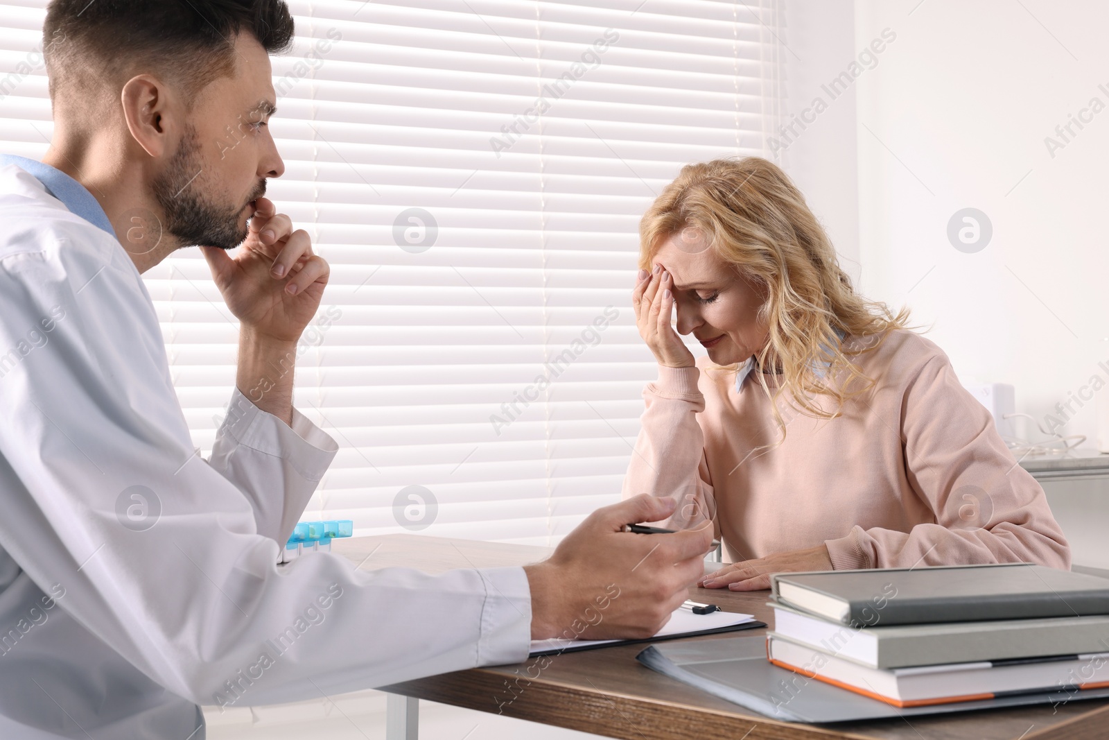 Photo of Doctor listening to patient's complaints during consultation in clinic