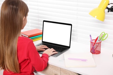 E-learning. Girl using laptop during online lesson at table indoors