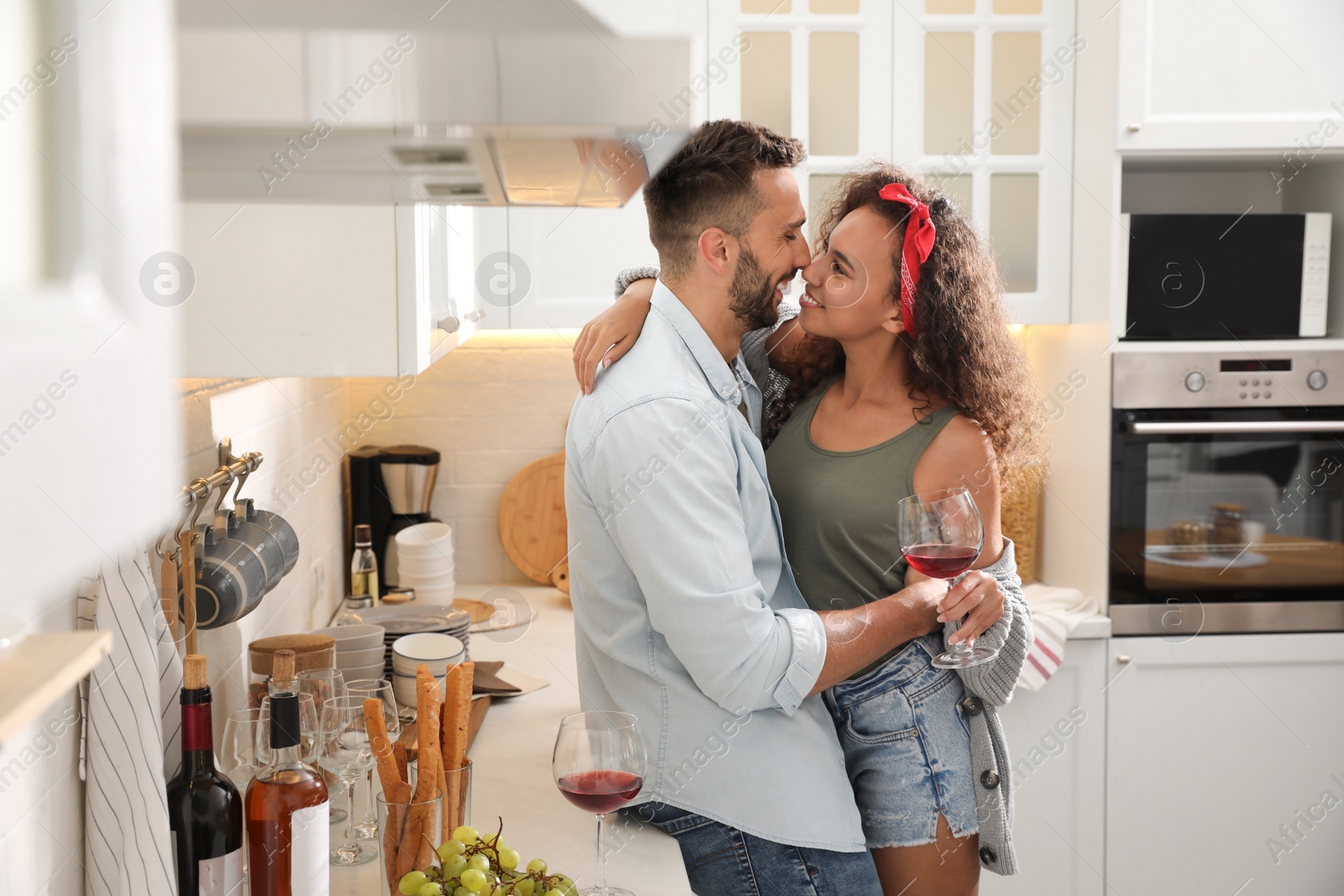 Photo of Lovely couple enjoying time together during romantic dinner in kitchen