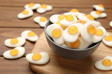 Photo of Delicious gummy fried eggs shaped candies on wooden table, closeup. Space for text