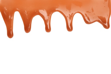 Photo of Delicious caramel sauce flowing on white background