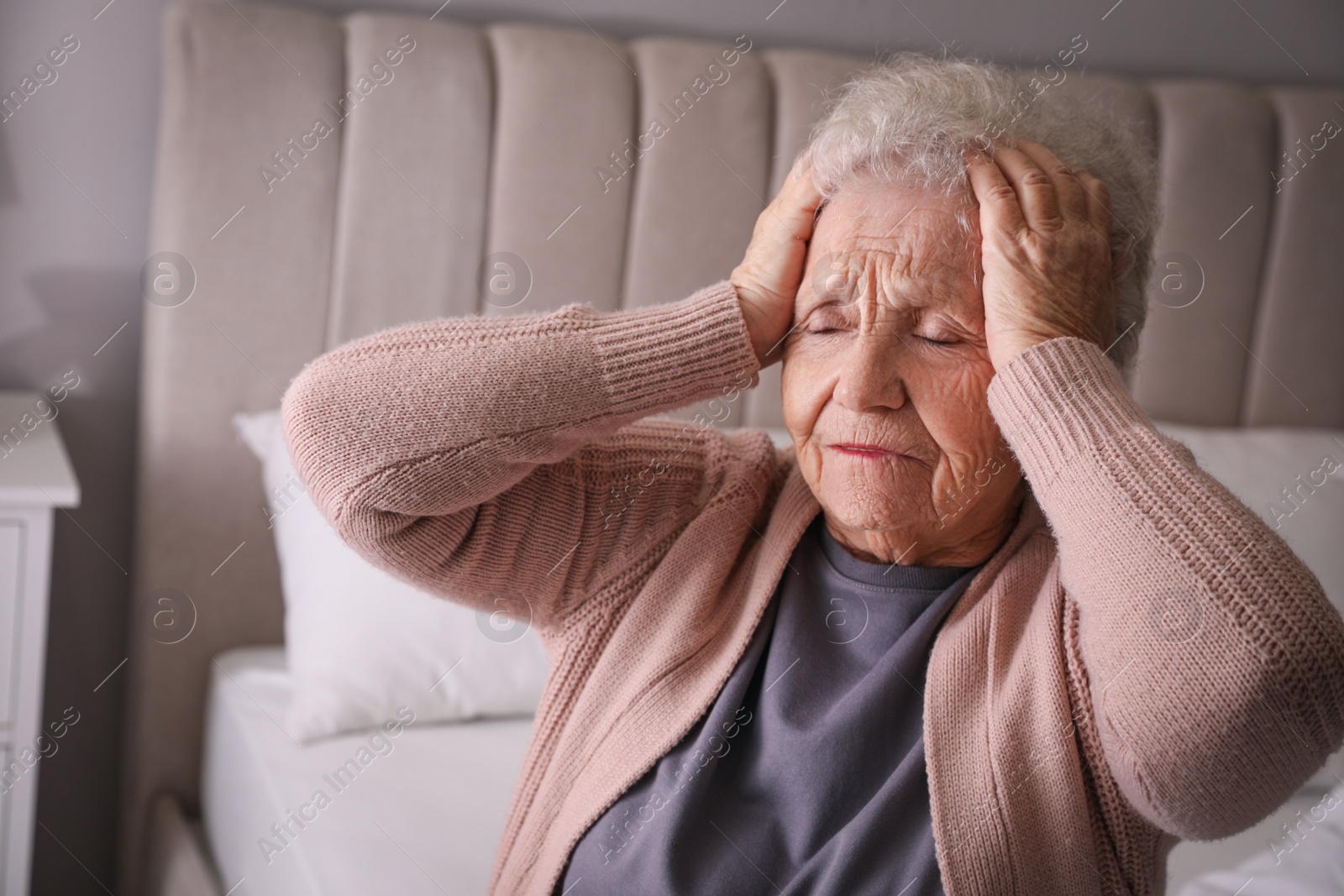 Photo of Senior woman with headache in bedroom at home