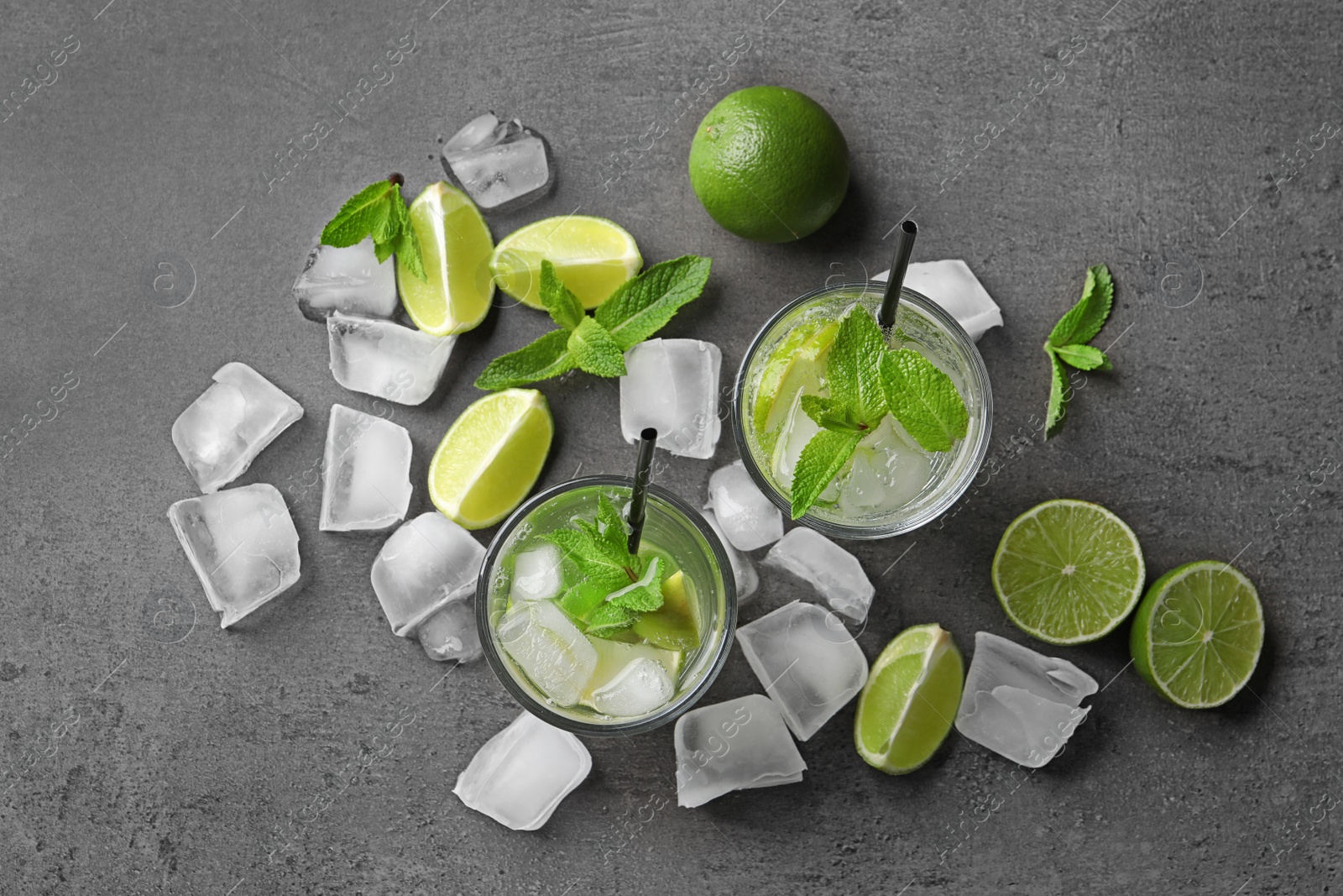 Photo of Flat lay composition with refreshing lime beverage and ingredients on grey background