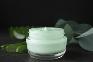 Photo of Jar of organic cream on black stone table