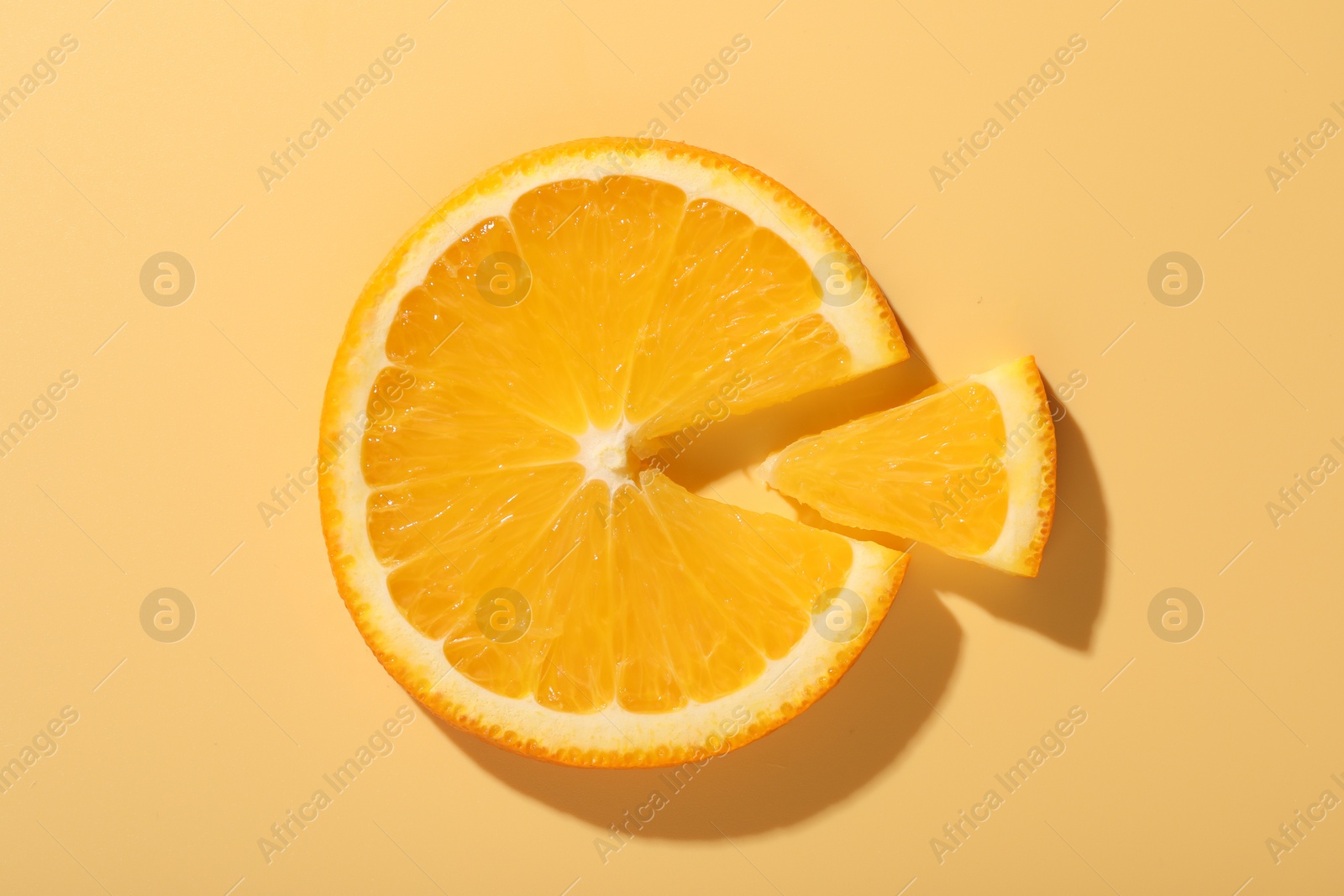 Photo of Slices of juicy orange on beige background, top view