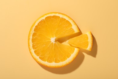 Slices of juicy orange on beige background, top view