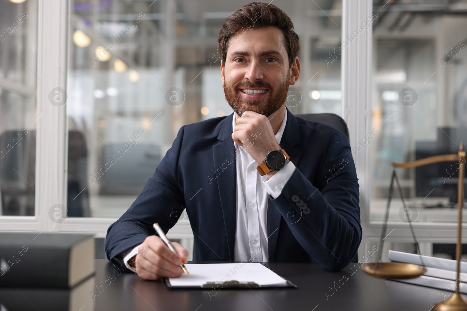 Photo of Portrait of smiling lawyer at table in office