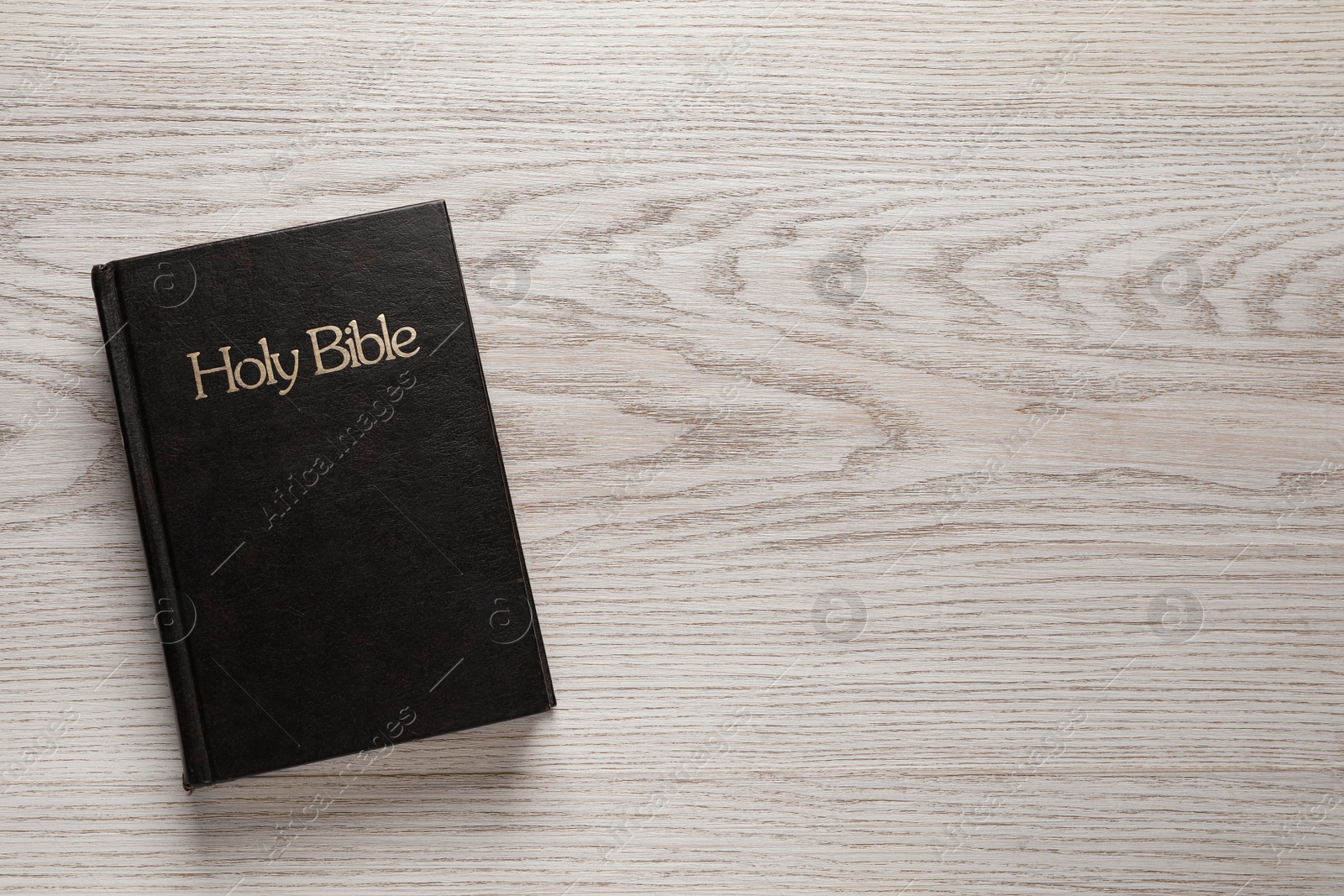 Photo of Bible on wooden table, top view with space for text. Christian religious book