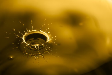 Image of Splash of golden oily liquid with drops as background, closeup