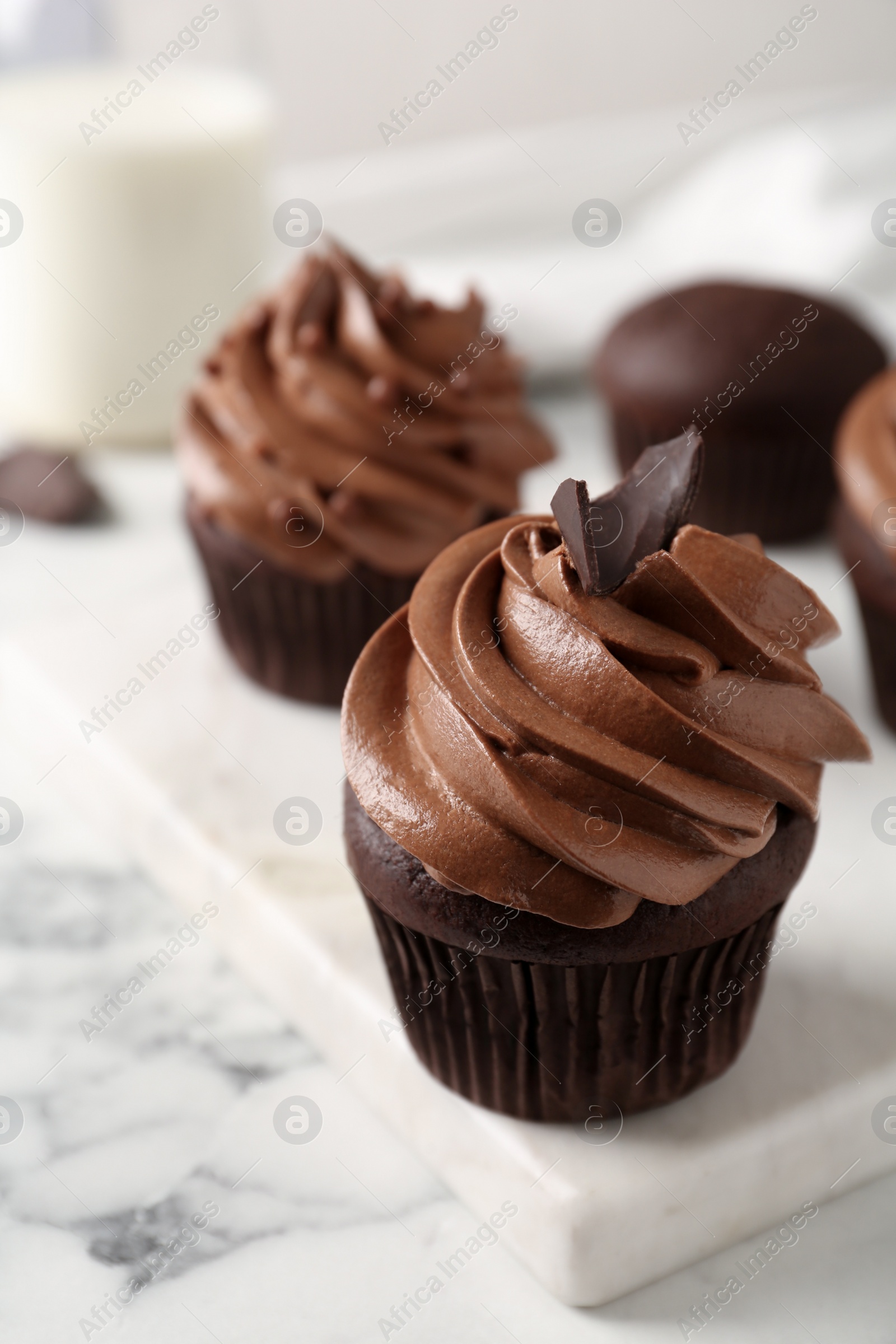 Photo of Delicious cupcakes decorated with cream on white marble table