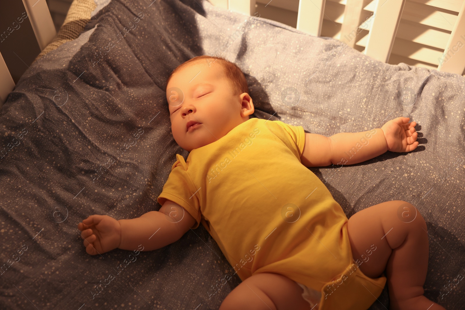 Photo of Cute newborn baby sleeping in crib indoors