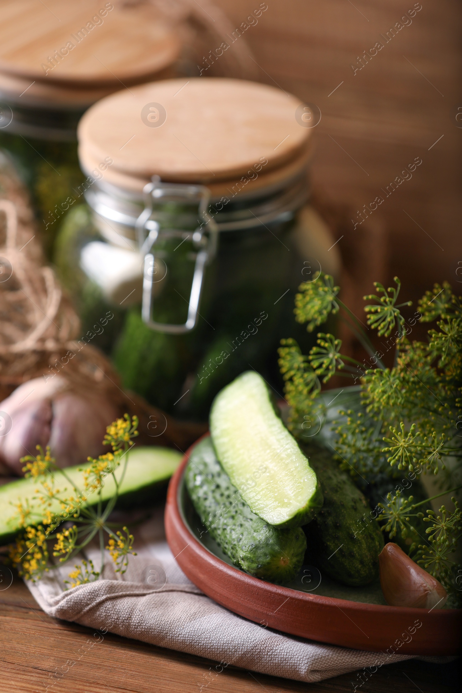 Photo of Fresh cucumbers and other ingredients prepared for canning on wooden table