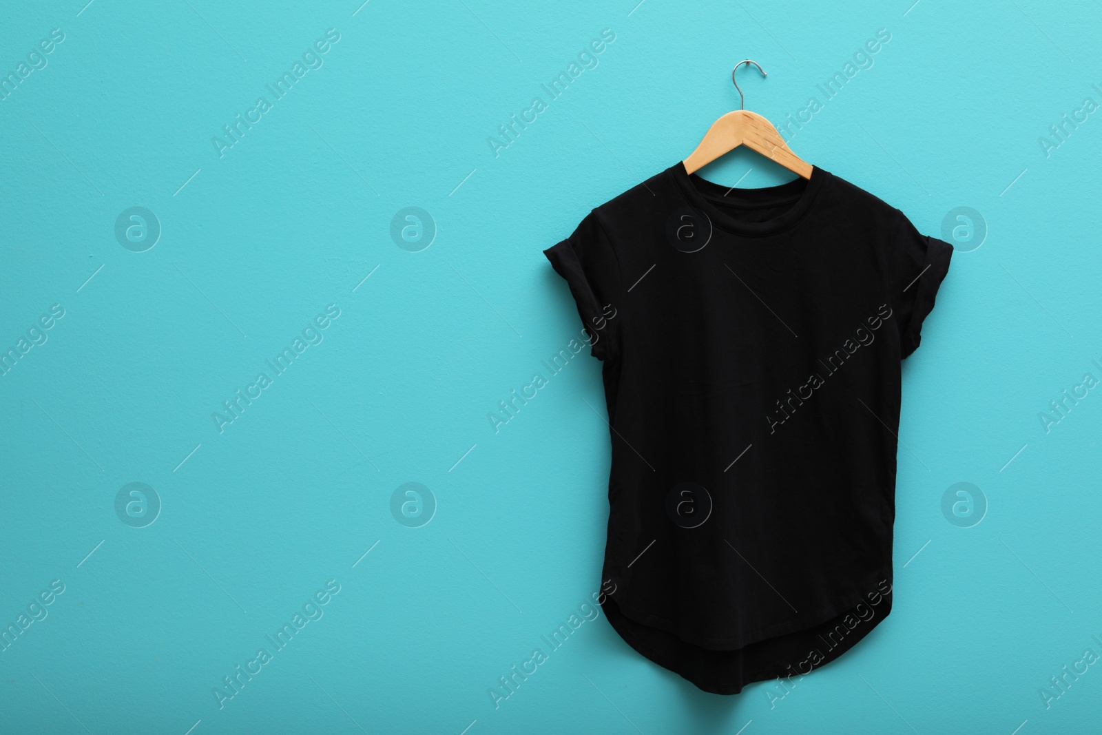 Photo of Hanger with blank t-shirt on color background. Mockup for design