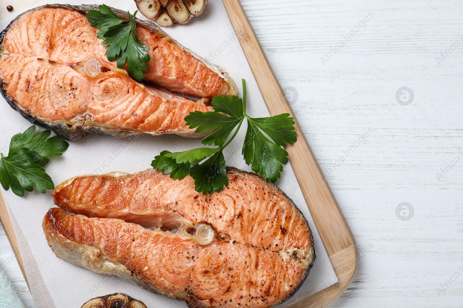 Photo of Tasty cooked red fish on white wooden table, top view