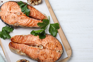 Tasty cooked red fish on white wooden table, top view