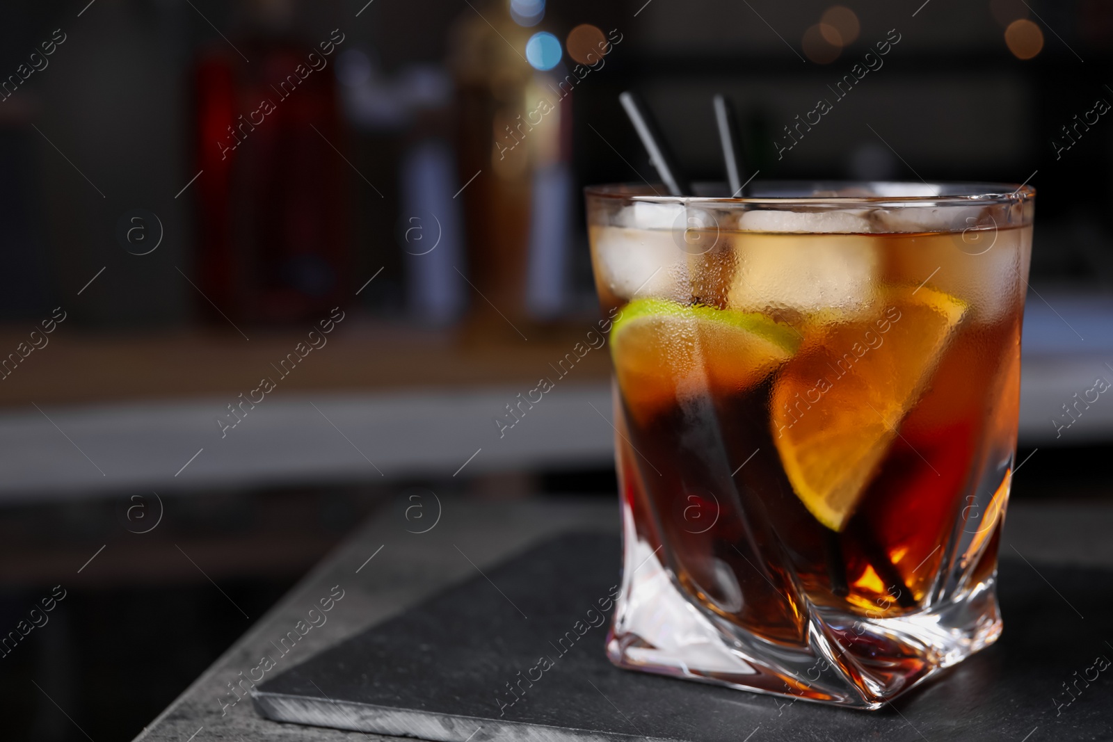 Photo of Cuba Libre cocktail on table in bar. Space for text