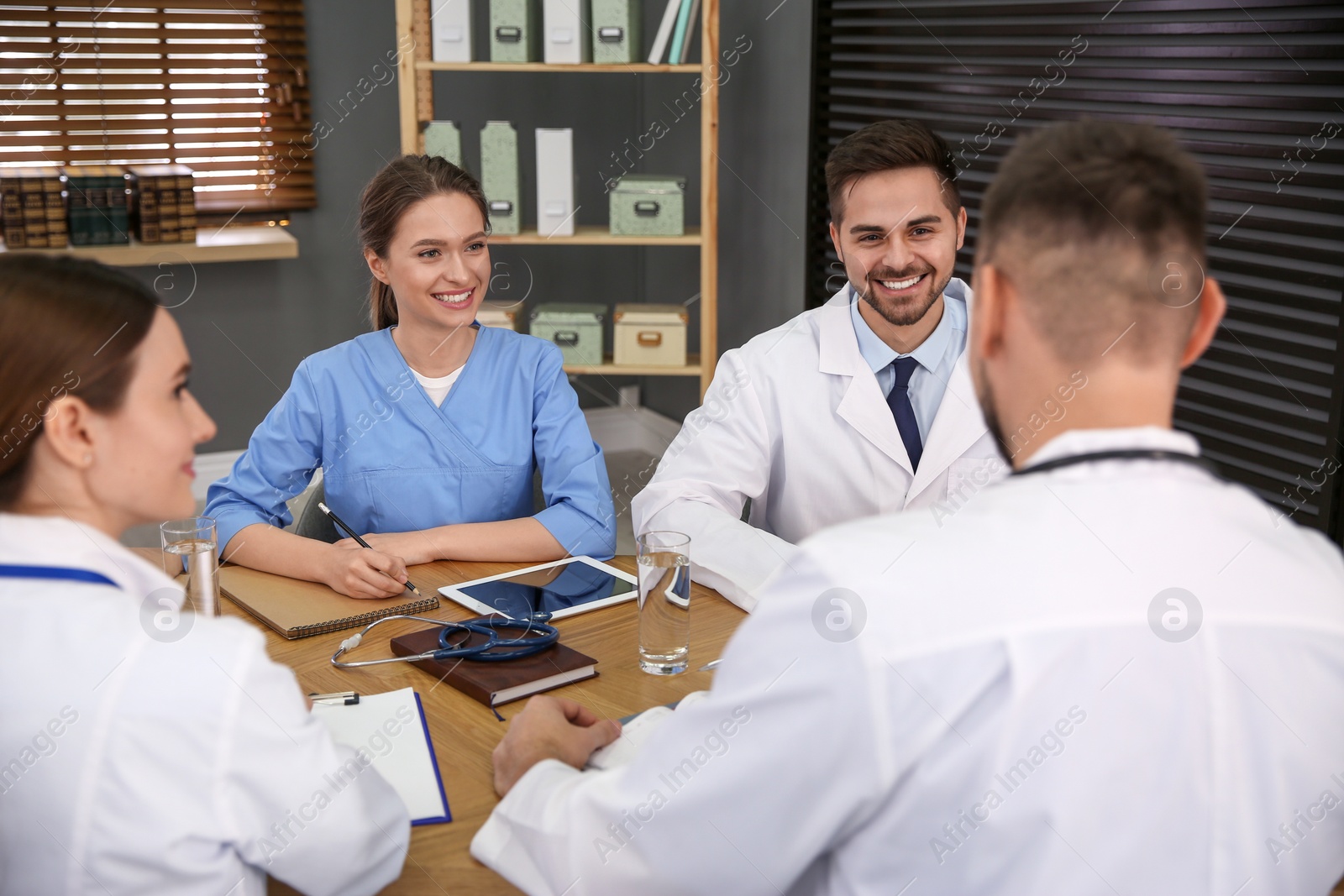 Photo of Team of professional doctors having meeting in office