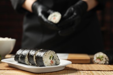 Tasty sushi rolls on wooden table, closeup