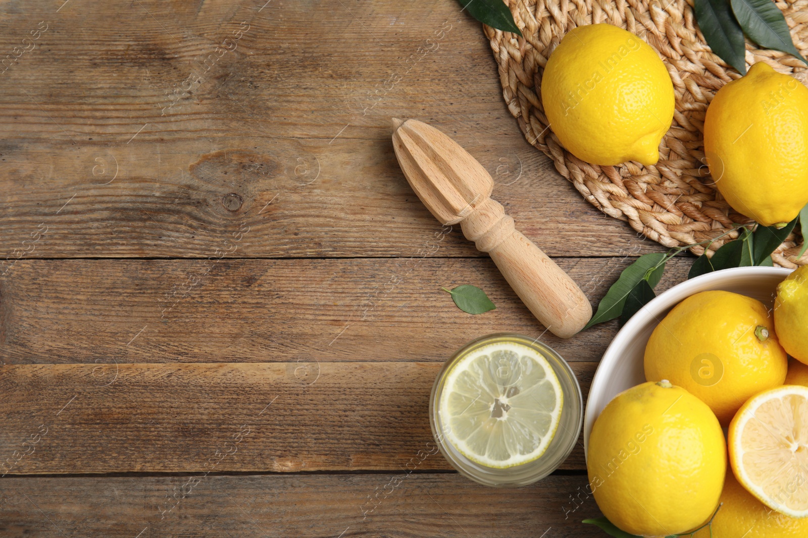 Photo of Squeezer with lemons on wooden table, flat lay. Space for text